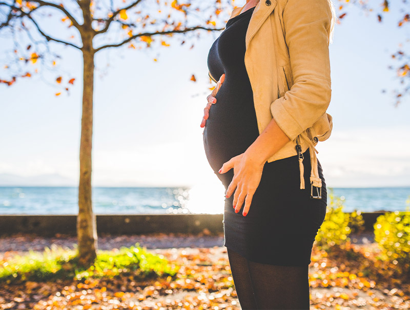 Pregnant woman with ocean in background image