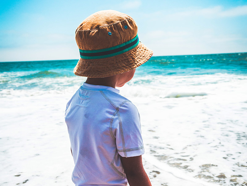 Child on beach wearing bucket hat image
