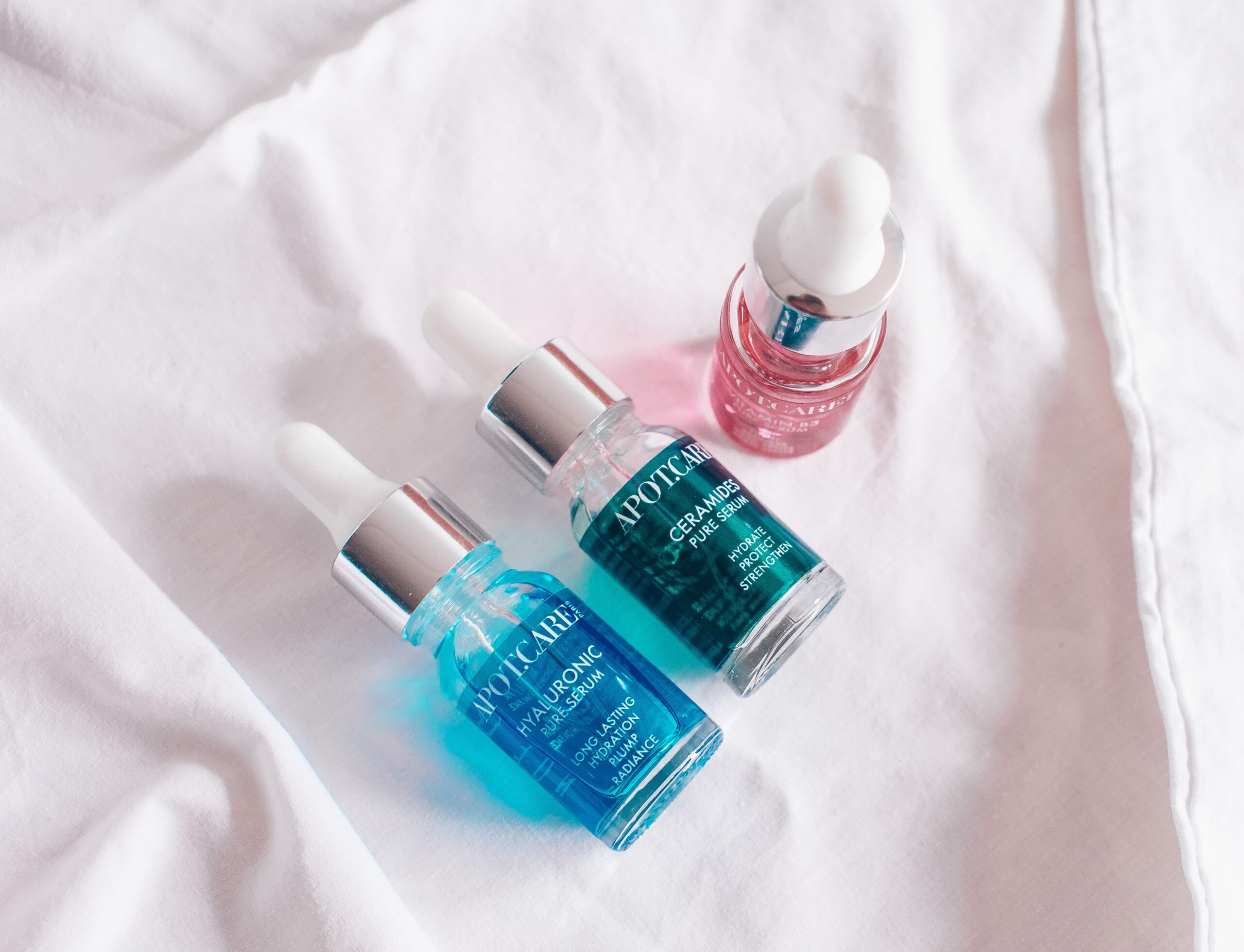 three skin serums laying on table