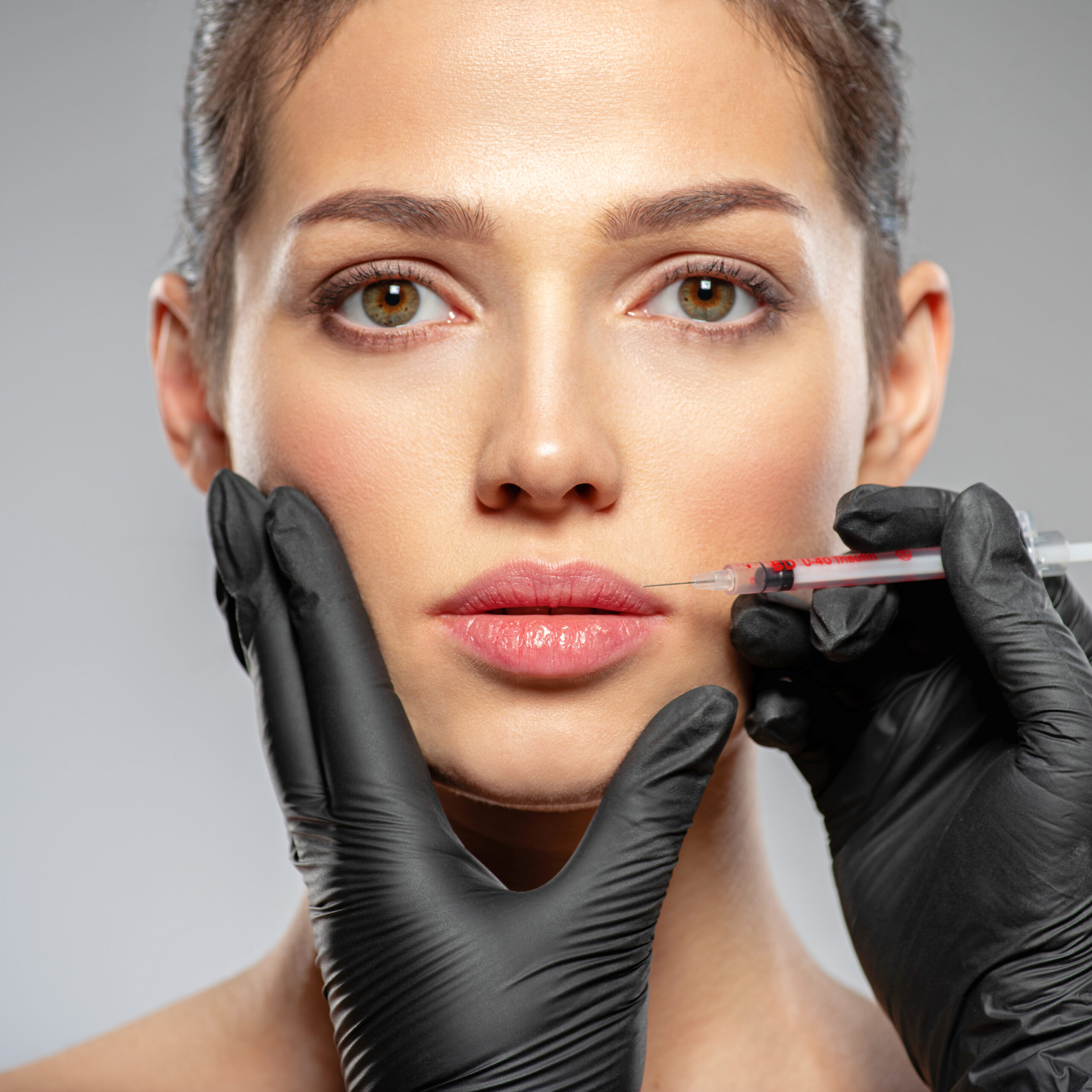 Caucasian woman getting botox cosmetic injection in the lips. Wo