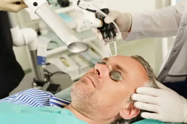 Doctor and middle aged male during laser skin resurfacing treatment